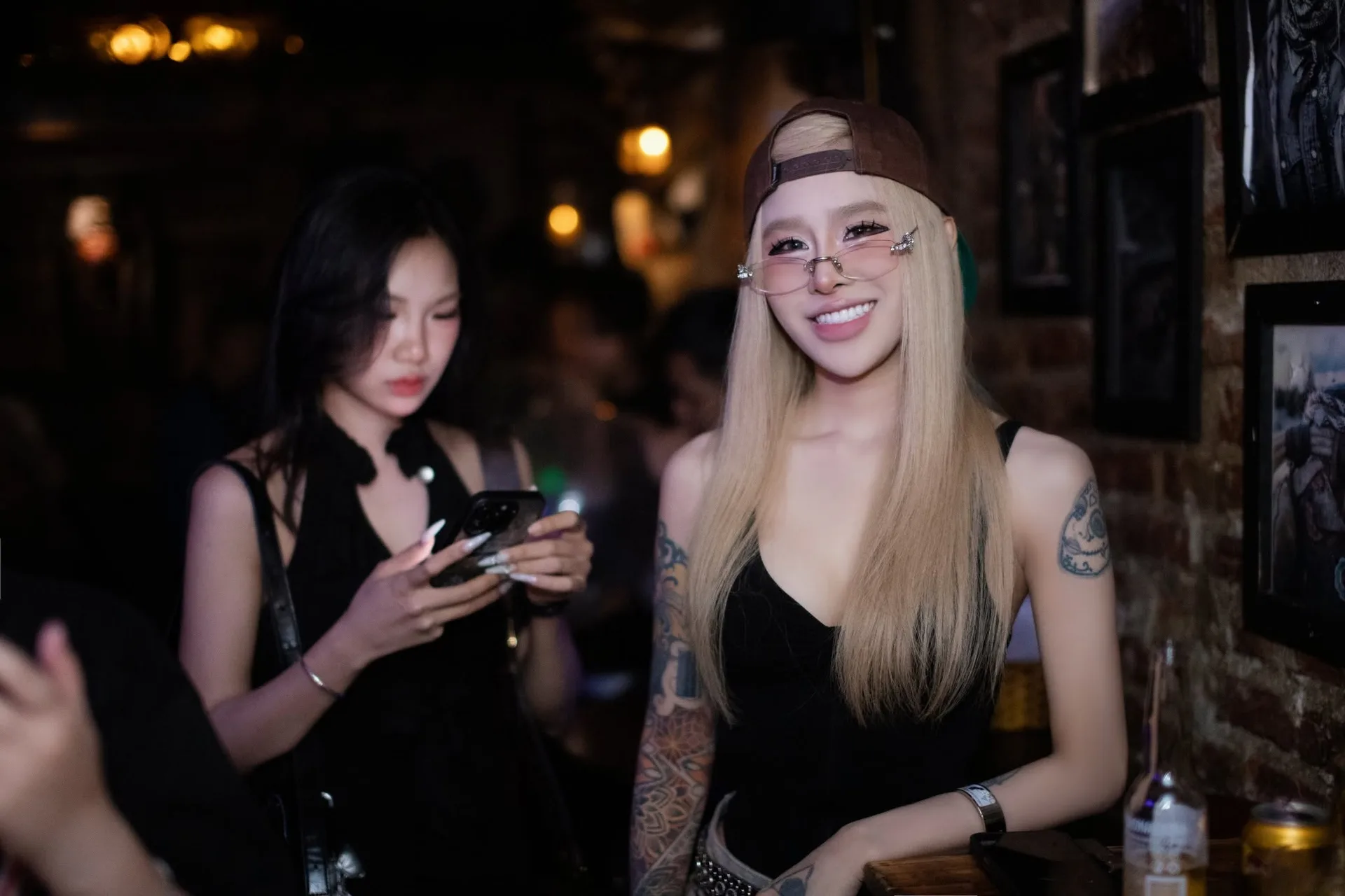Khách nữ trong không gian tường gạch và ảnh treo tại Sixsense Saloon